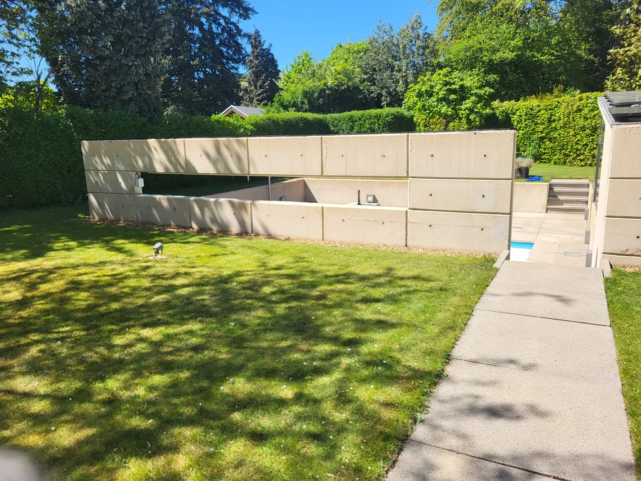 Betonnen wand bij zwembad in Geleen na professionele reiniging