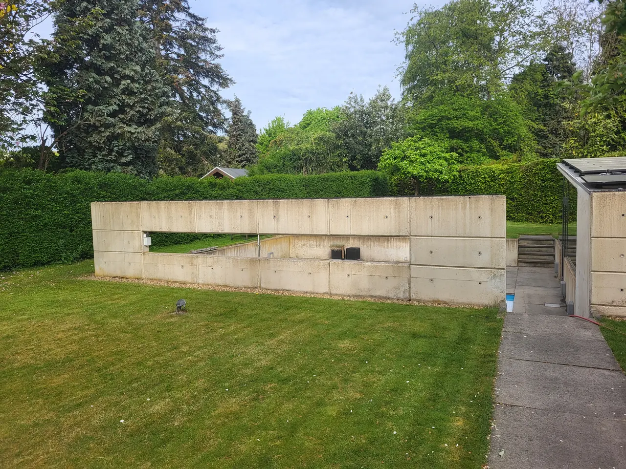 Betonnen wand bij zwembad in Geleen voor professionele reiniging